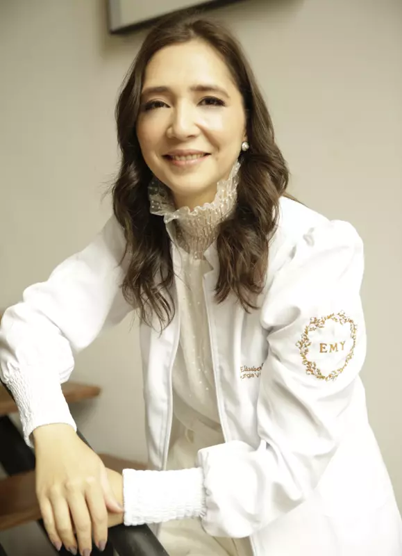Doutora Elisabeth Yano sorrindo para a foto no ambiente do seu consultório