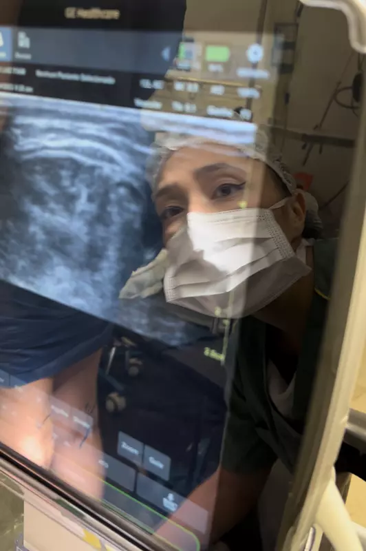 Doutora Elisabeth Yano analisando um monitor de ultrassom no procedimento de varizes